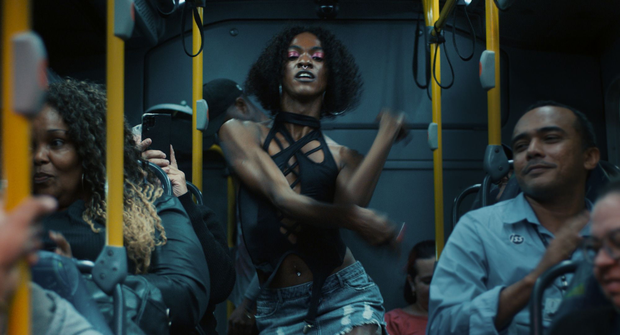Still of character voguing in the aisle of a bus