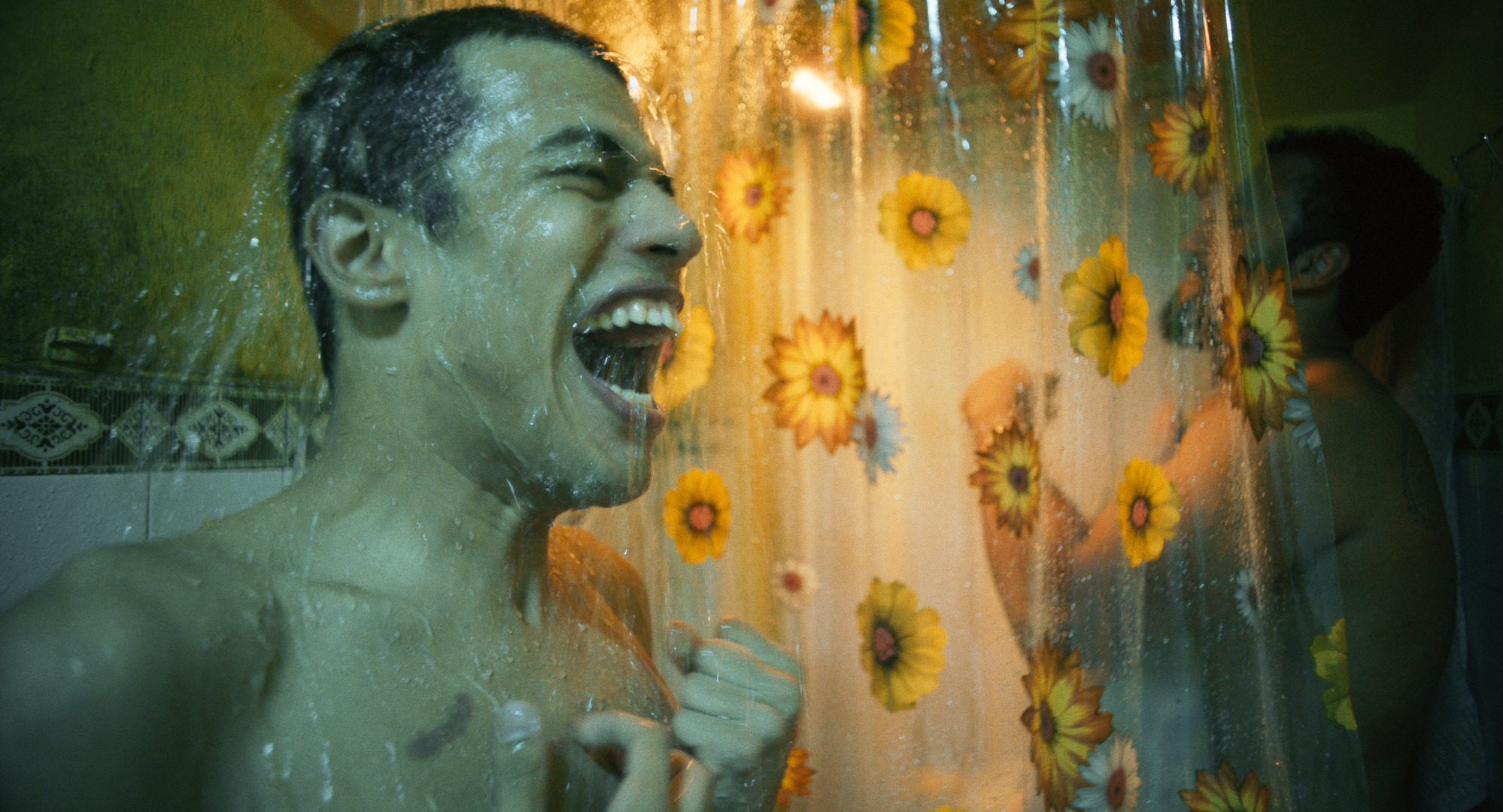 Excited man shocked underneath a cold shower
