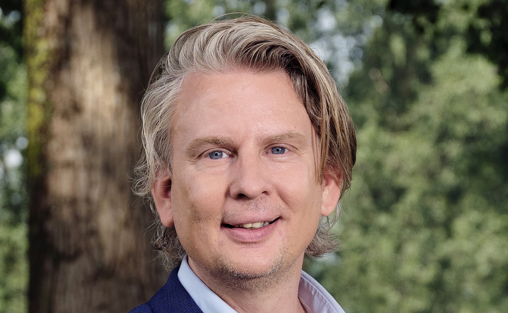 portret van David Lauwen; een blonde man in blauw pak kijkt direct naar de camera